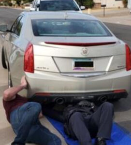 Vehicle being checked for GPS tracker by private investigator.
